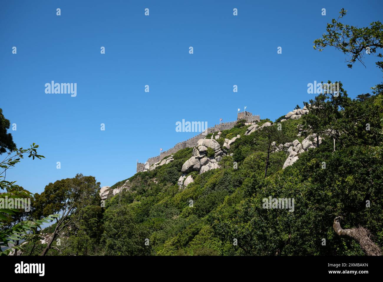 Vista ad angolo basso di Castelo dos Mouros (Castello dei Mori) sotto un cielo azzurro - Sintra, Portogallo Foto Stock