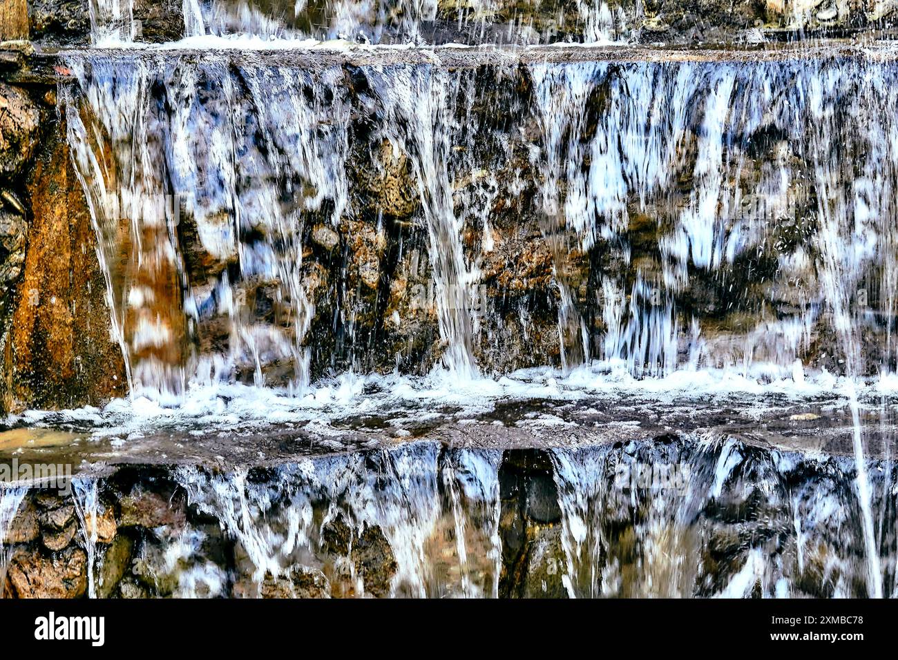 un liquido incolore, trasparente e inodore che forma i mari, i laghi, i fiumi e la pioggia ed è la base dei fluidi degli organismi viventi. Foto Stock