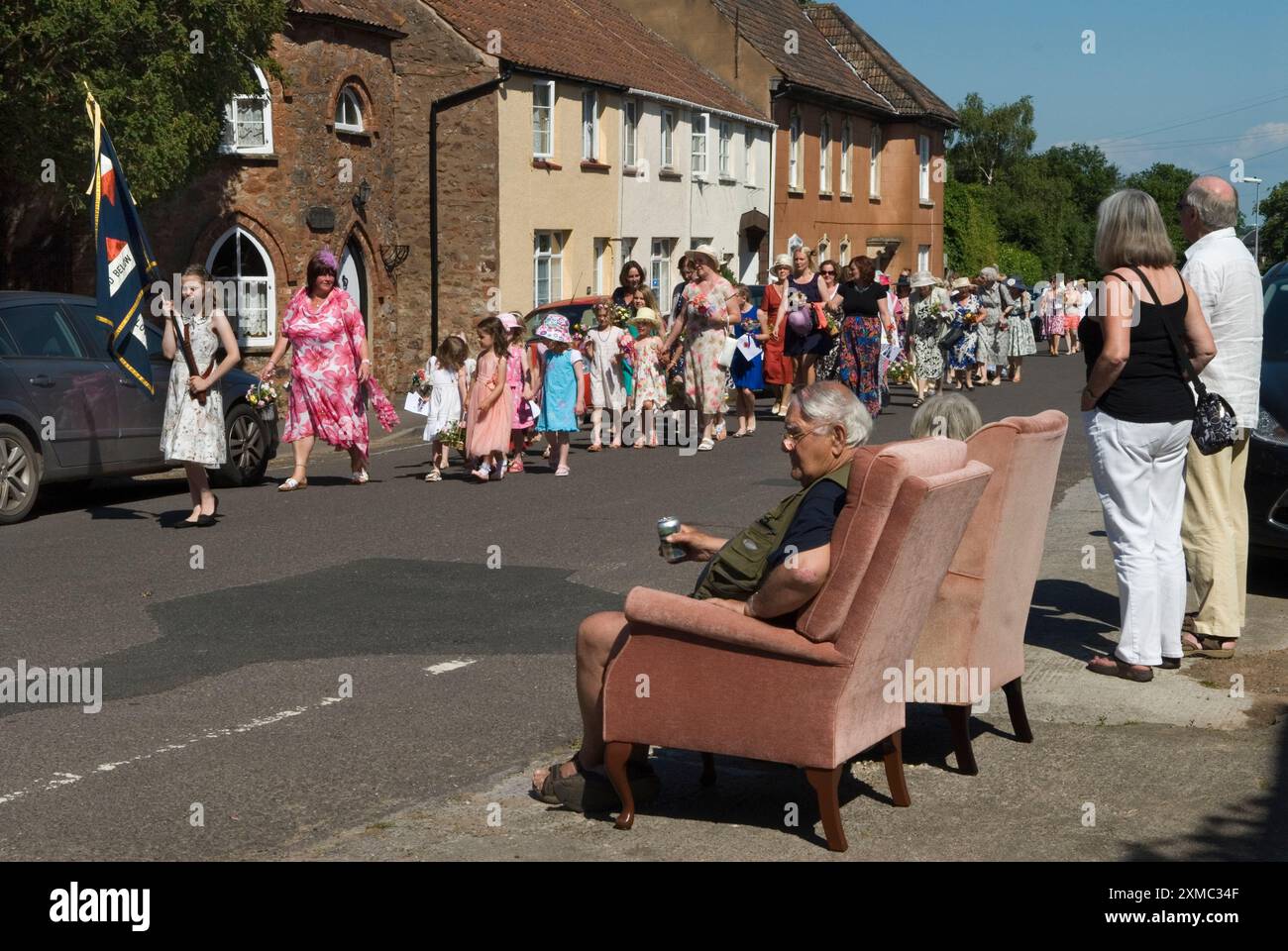Nether Stowey Female Friendly Society; The Womens Walk il giorno del Club. Camminano fino alla tomba nella chiesa di St Marys del loro fondatore, l'uomo d'affari locale Tom Poole e poi tornano attraverso il villaggio. Alcuni locali si riuniscono per assistere alla sfilata. Nether Stowey, Somerset, Inghilterra 21 giugno 2014. HOMER SYKES DEGLI ANNI '2010 DEL REGNO UNITO Foto Stock