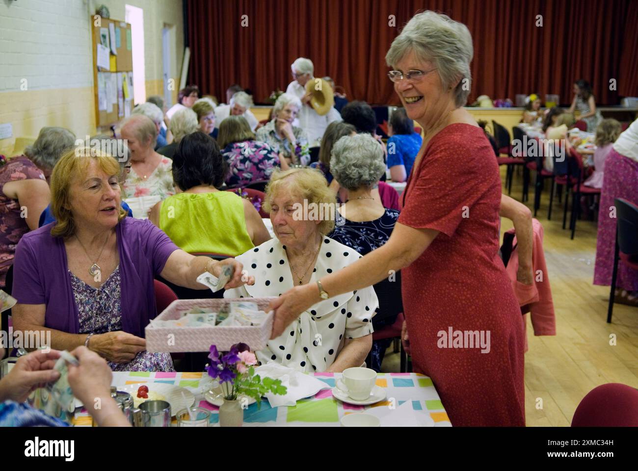 Village Hall a Cream Tea. The Nether Stowey Female Friendly Society; The Womens Walk il giorno del Club. I membri a raccolgono il costo del tè alla panna, che era di £ 5,00 nel 2014. Una donna paga con un biglietto da 5,00 sterline. Un vassoio di banconote da 5 libbre. Nether Stowey, Somerset, Inghilterra 21 giugno Regno Unito 2010s HOMER SYKES Foto Stock