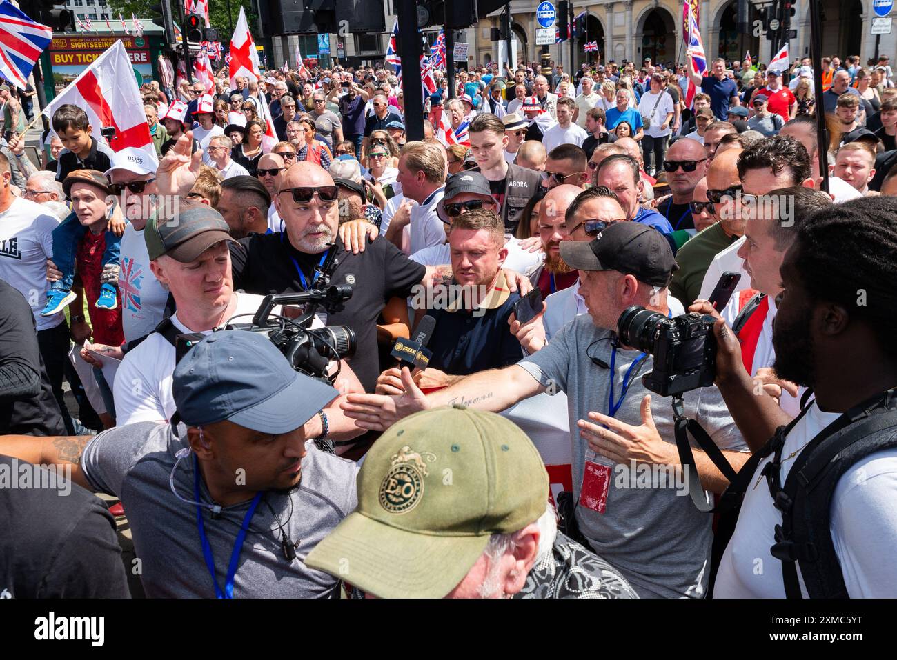 Westminster, Londra, Regno Unito. 27 luglio 2024. I sostenitori di Tommy Robinson si riunirono nello Strand presso la Royal Courts of Justice per una marcia di protesta verso Trafalgar Square. I temi della protesta includono l'immigrazione, e una protesta avversaria organizzata da Stand Up to Racism si sta dirigendo verso la vicina Whitehall con 1000 agenti di polizia in servizio per scoraggiare gli scontri. Tommy Robinson ha partecipato, portando folle di seguaci a Trafalgar Square con media e minatori Foto Stock
