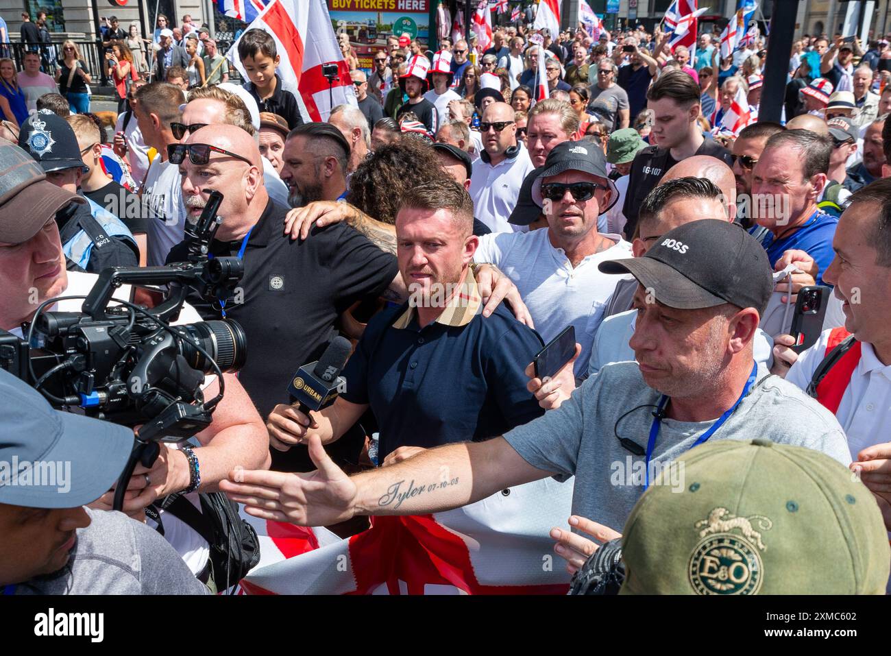 Westminster, Londra, Regno Unito. 27 luglio 2024. I sostenitori di Tommy Robinson si riunirono nello Strand presso la Royal Courts of Justice per una marcia di protesta verso Trafalgar Square. I temi della protesta includono l'immigrazione, e una protesta avversaria organizzata da Stand Up to Racism si sta dirigendo verso la vicina Whitehall con 1000 agenti di polizia in servizio per scoraggiare gli scontri. Tommy Robinson ha partecipato, portando folle di seguaci a Trafalgar Square con media e minatori Foto Stock