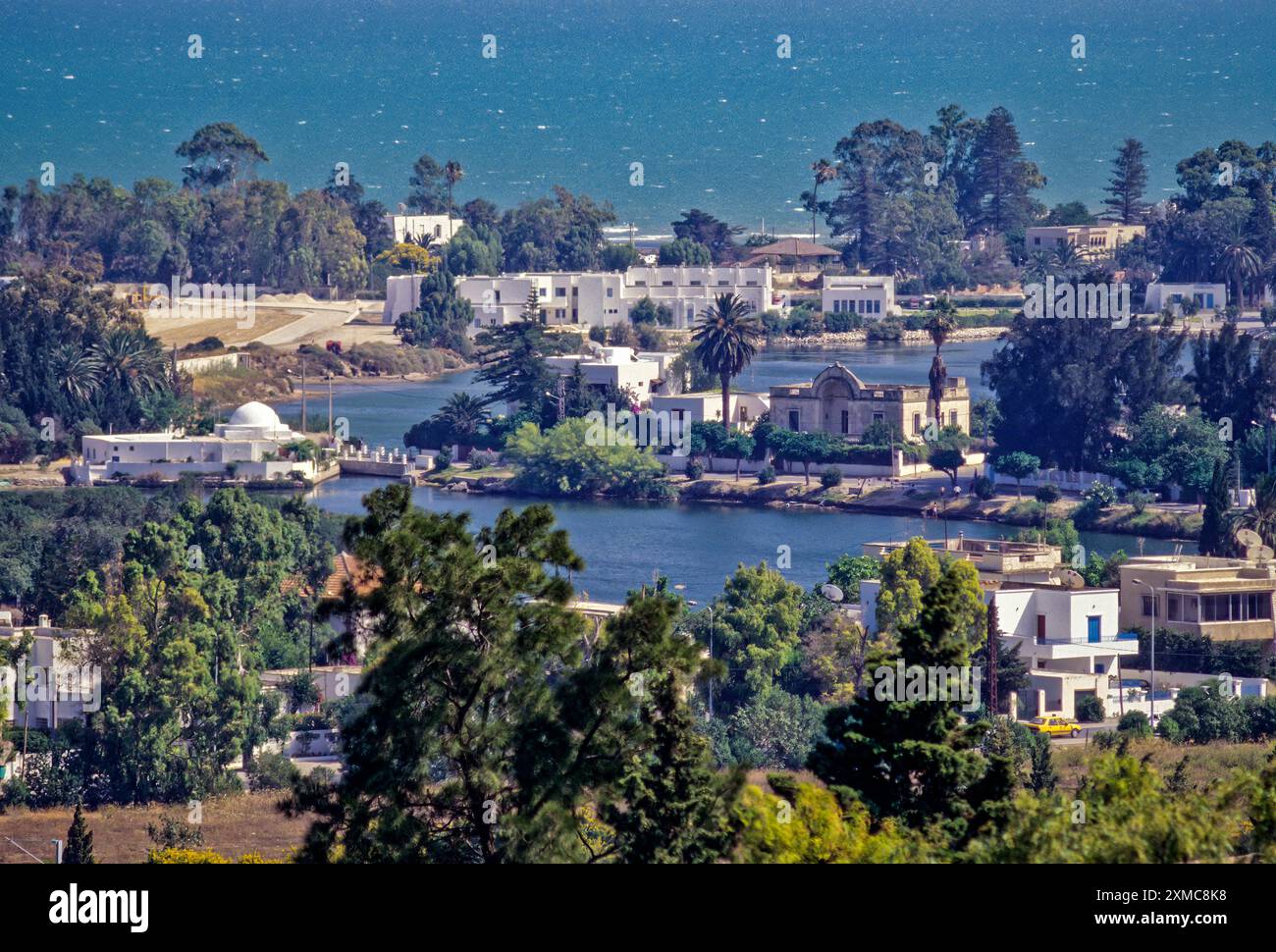 Cartagine, Tunisia. Porti punici, ora simili a piccoli laghi delimitato dalle lussuose case, data dal 4th. Secolo a.c. Il primo piano è stato il naval, o militari, Porto. Il porto commerciale è adiacente, più indietro. Baia di Tunisi in background. Foto Stock