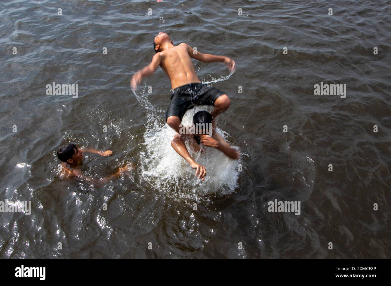 Srinagar, Jammu e Kashmir, India. 27 luglio 2024. I ragazzi kashmiri si stanno rinfrescando facendo un tuffo rinfrescante nelle acque del lago dal in una calda giornata estiva a Srinagar. Secondo un rapporto delle Nazioni Unite, l'India ha riportato 40.000 casi di sospetti colpi di calore e oltre 100 morti entro la metà di giugno di quest'anno, che ha sollecitato l'azione per frenare gli effetti del caldo estremo. (Immagine di credito: © Adil Abass/ZUMA Press Wire) SOLO PER USO EDITORIALE! Non per USO commerciale! Foto Stock