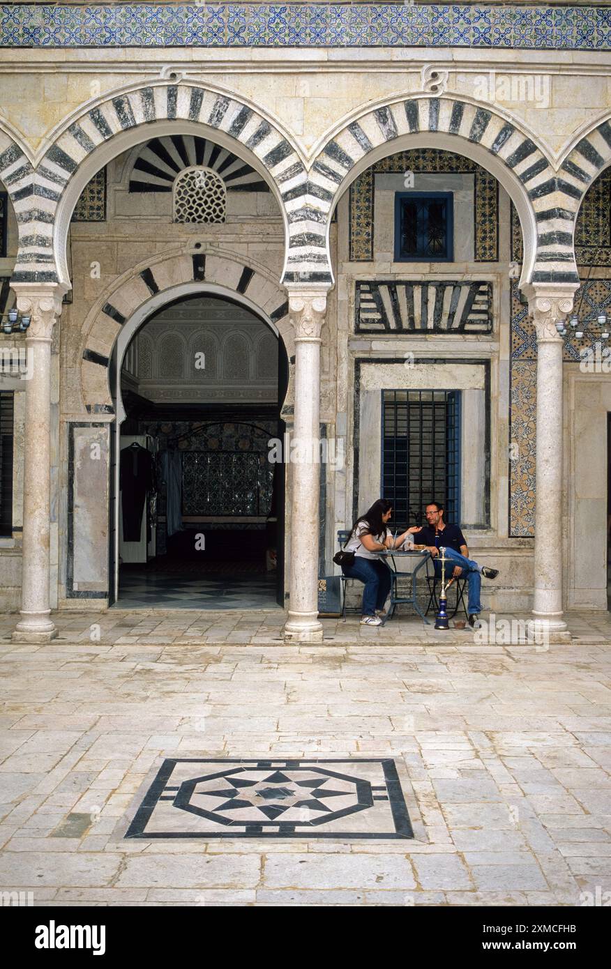 Tunisia. Tunisi Medina. Dar Hamouda Pacha, fine 18. Secolo. Ora un ristorante e una casa da tè. Coppia che si diverte a conversare e una Sheesha. Informale Foto Stock