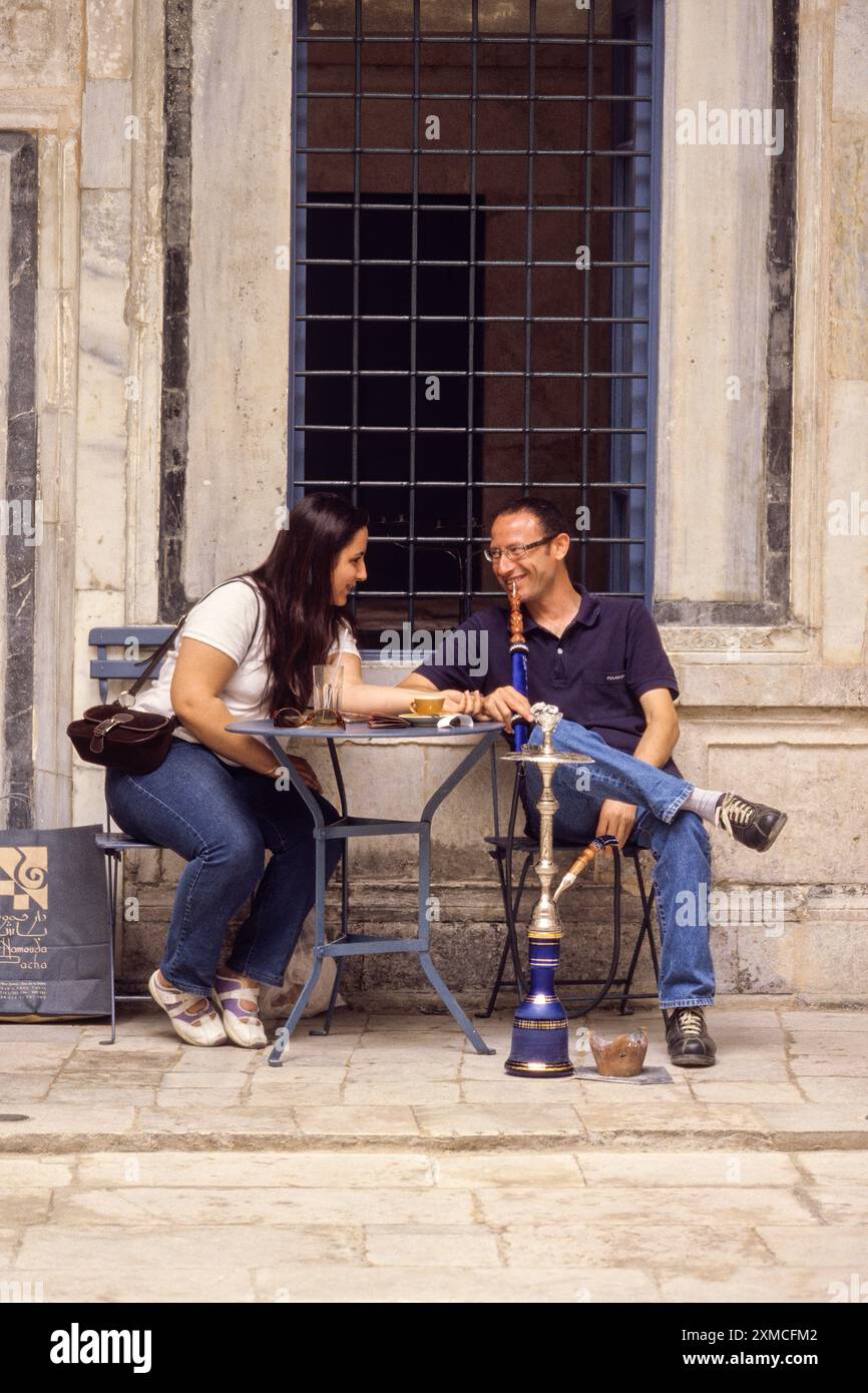Tunisia. Tunisi Medina. Dar Hamouda Pacha, fine 18. Secolo. Ora un ristorante e una casa da tè. Coppia che si diverte a conversare e una Sheesha. Informale Foto Stock