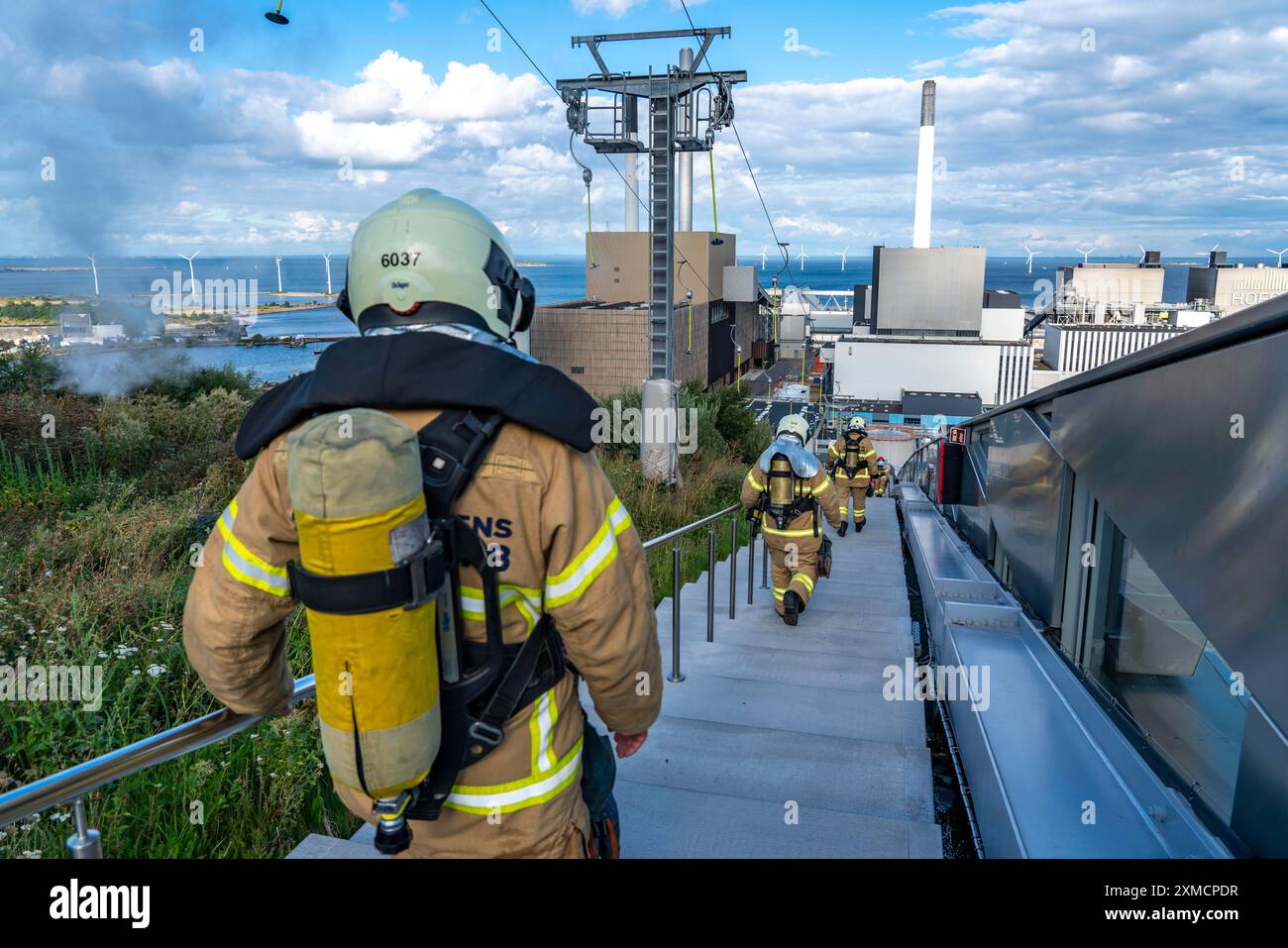 CopenHill, impianto di incenerimento dei rifiuti e pista da sci artificiale, vigili del fuoco sotto protezione respiratoria, allenamento di resistenza, sci con vista su Foto Stock