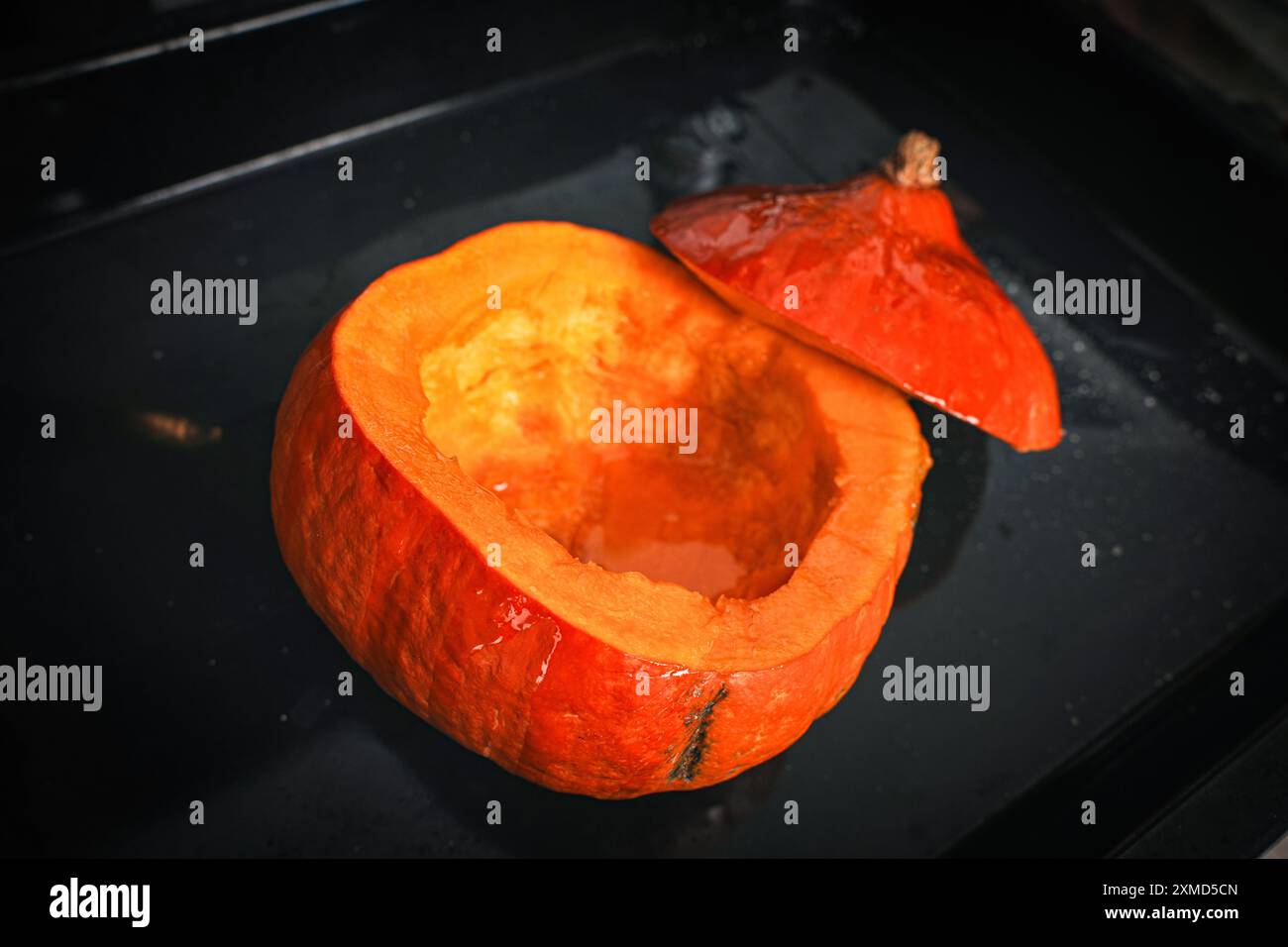 Zucca intera cotta nel forno con la parte superiore tagliata. Zucca pronta per essere versata nella zuppa. Ricetta per la zuppa. Foto di alta qualità Foto Stock