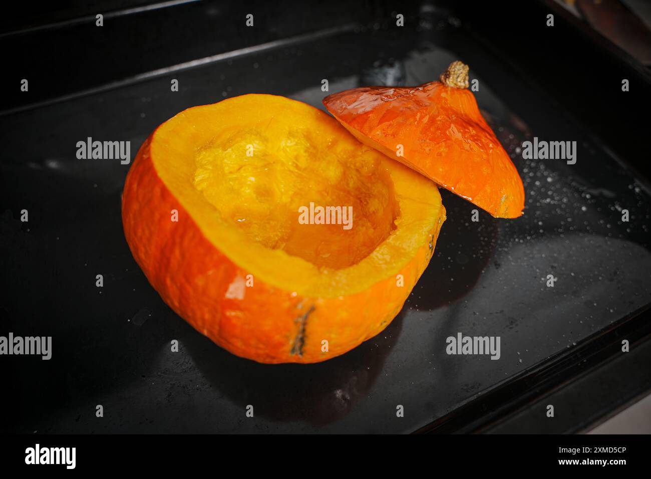 Zucca intera cotta nel forno con la parte superiore tagliata. Zucca pronta per essere versata nella zuppa. Ricetta per la zuppa. Foto di alta qualità Foto Stock