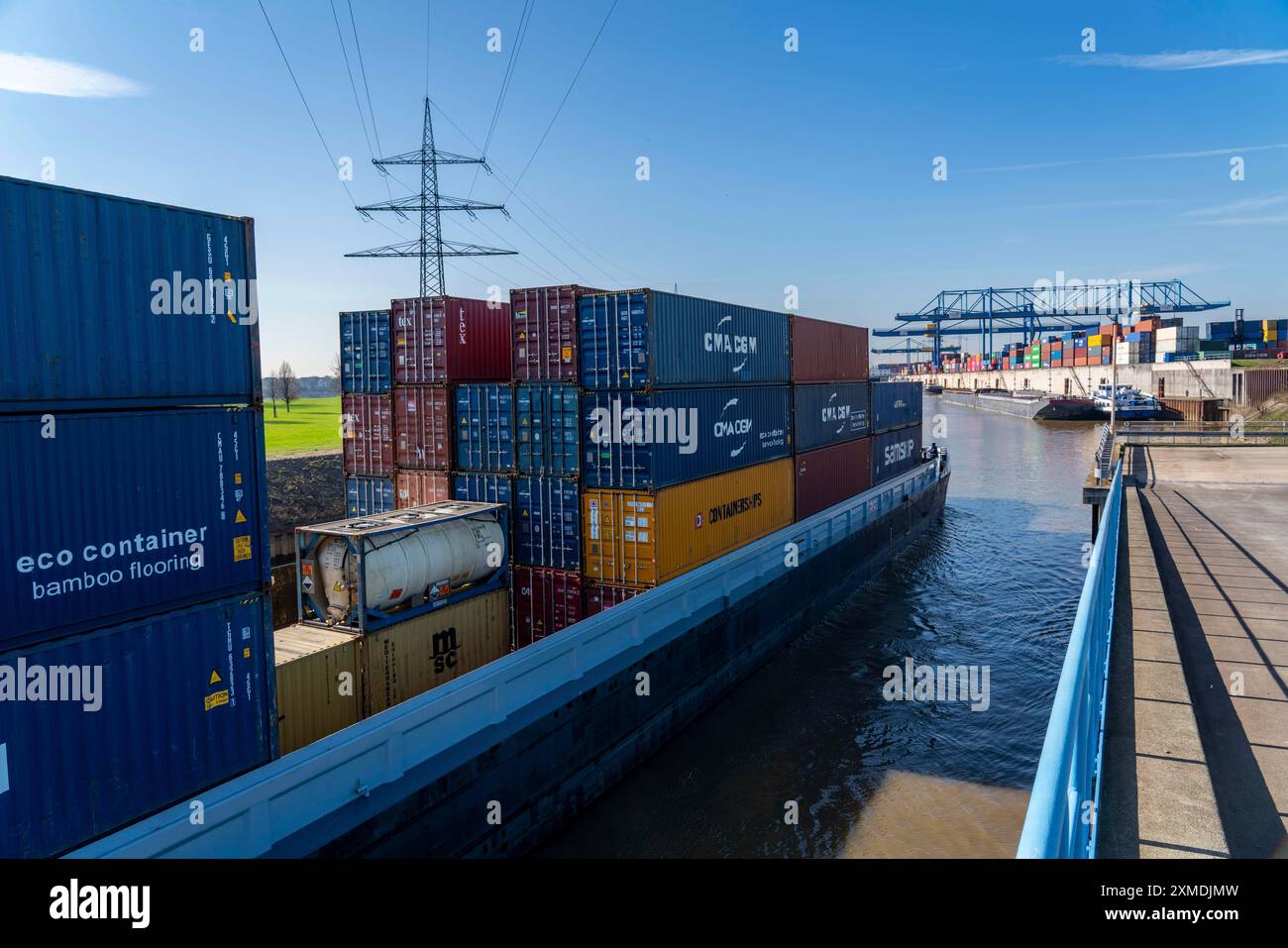 La nave da carico container entra nel bacino del porto del Logport, le gru a cavalletto nel centro di movimentazione container, il terminal container trimodale, nel Foto Stock