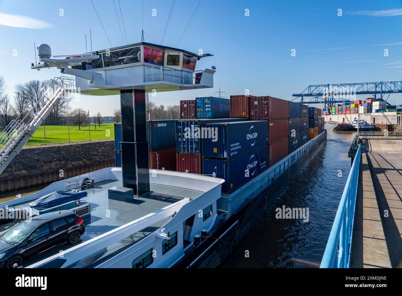 La nave da carico container entra nel bacino del porto del Logport, le gru a cavalletto nel centro di movimentazione container, il terminal container trimodale, nel Foto Stock