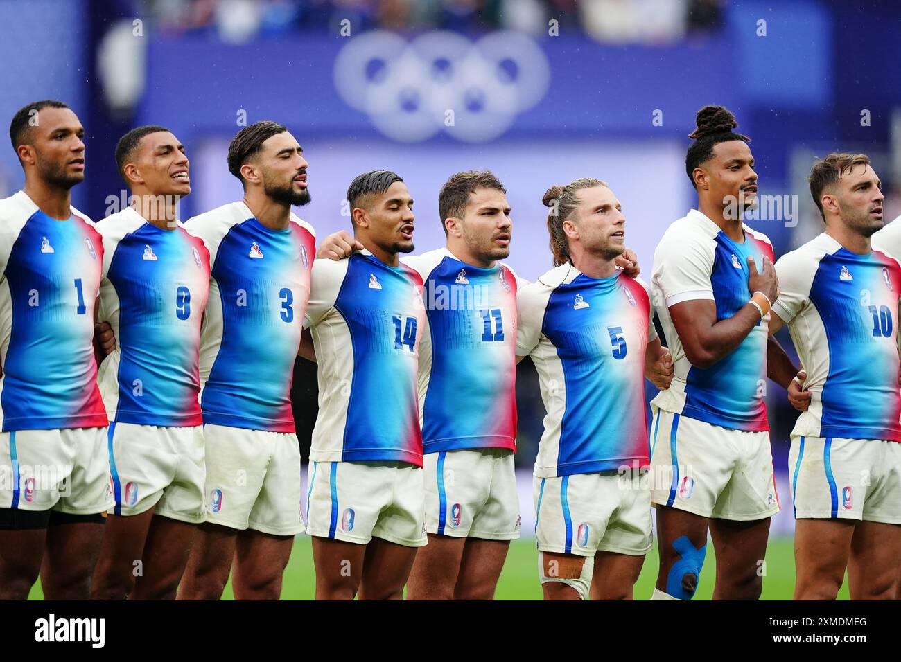 Antoine Dupont francese e i suoi compagni di squadra rappresentano gli inni nazionali durante la partita della medaglia d'oro allo Stade de France nel primo giorno dei Giochi Olimpici di Parigi del 2024 in Francia. Data foto: Sabato 27 luglio 2024. Foto Stock