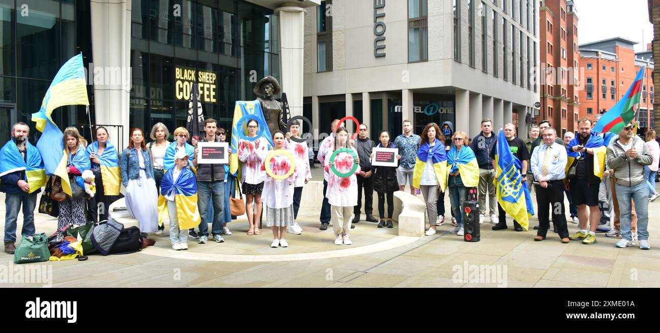 Manchester, Regno Unito, 27 luglio 2024. Protesta con l'Ucraina accanto alla statua di Emmeline Pankhurst in Piazza San Pietro, nel centro di Manchester, Regno Unito. I manifestanti fanno riferimento ai circoli dei Giochi Olimpici. Il cartello di sinistra recita: "488 atleti ucraini uccisi dalla Russia”. Il cartello a destra recita: "9 atleti russi che sostengono l'invasione invitati a partecipare alle Olimpiadi”. Questa è la 126a settimana questa protesta regolare ha avuto luogo a Manchester. Crediti: Terry Waller/Alamy Live News Foto Stock