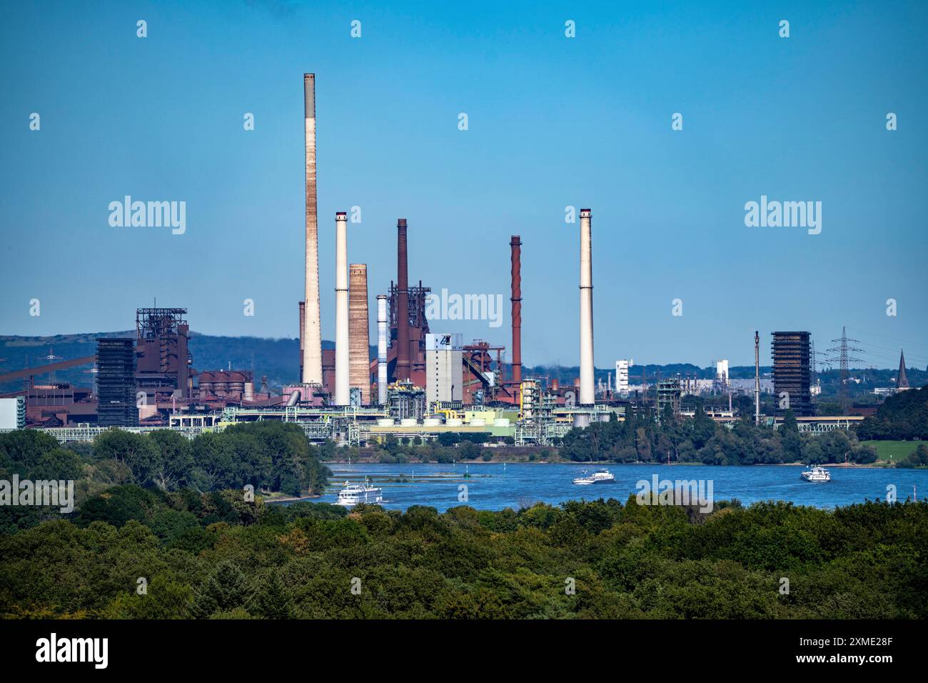 Vista sul Reno dell'acciaieria ThyssenKrupp di Duisburg-Beeckerwerth, altoforni, cokeria, paesaggio verde sulla riva sinistra Foto Stock