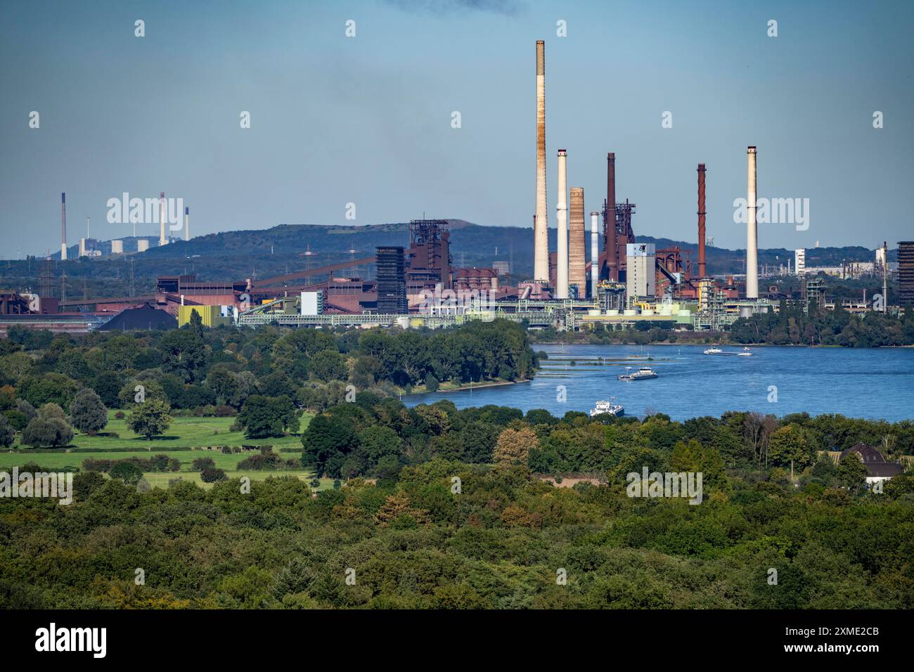 Vista sul Reno dell'acciaieria ThyssenKrupp di Duisburg-Beeckerwerth, altoforni, cokeria, paesaggio verde sulla riva sinistra Foto Stock