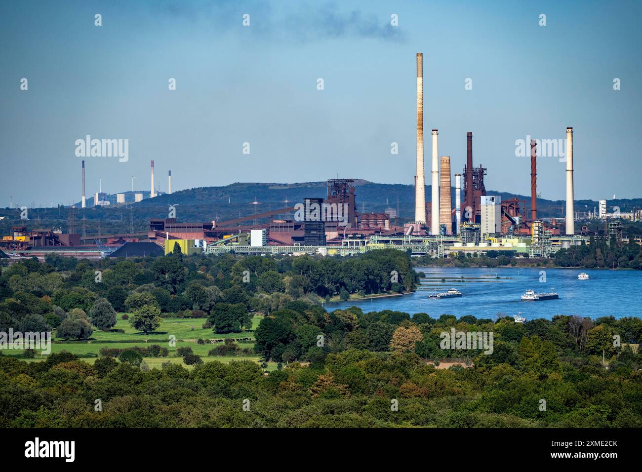 Vista sul Reno dell'acciaieria ThyssenKrupp di Duisburg-Beeckerwerth, altoforni, cokeria, paesaggio verde sulla riva sinistra Foto Stock