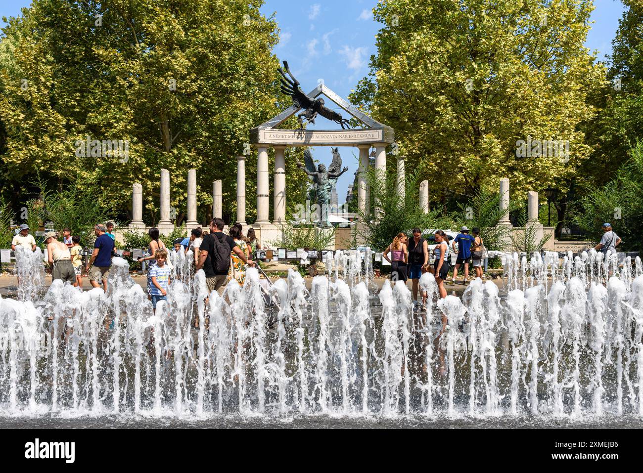 Persone nella fontana prima del controverso memoriale dell'occupazione tedesca a Szabadsag ter a Budapest Foto Stock