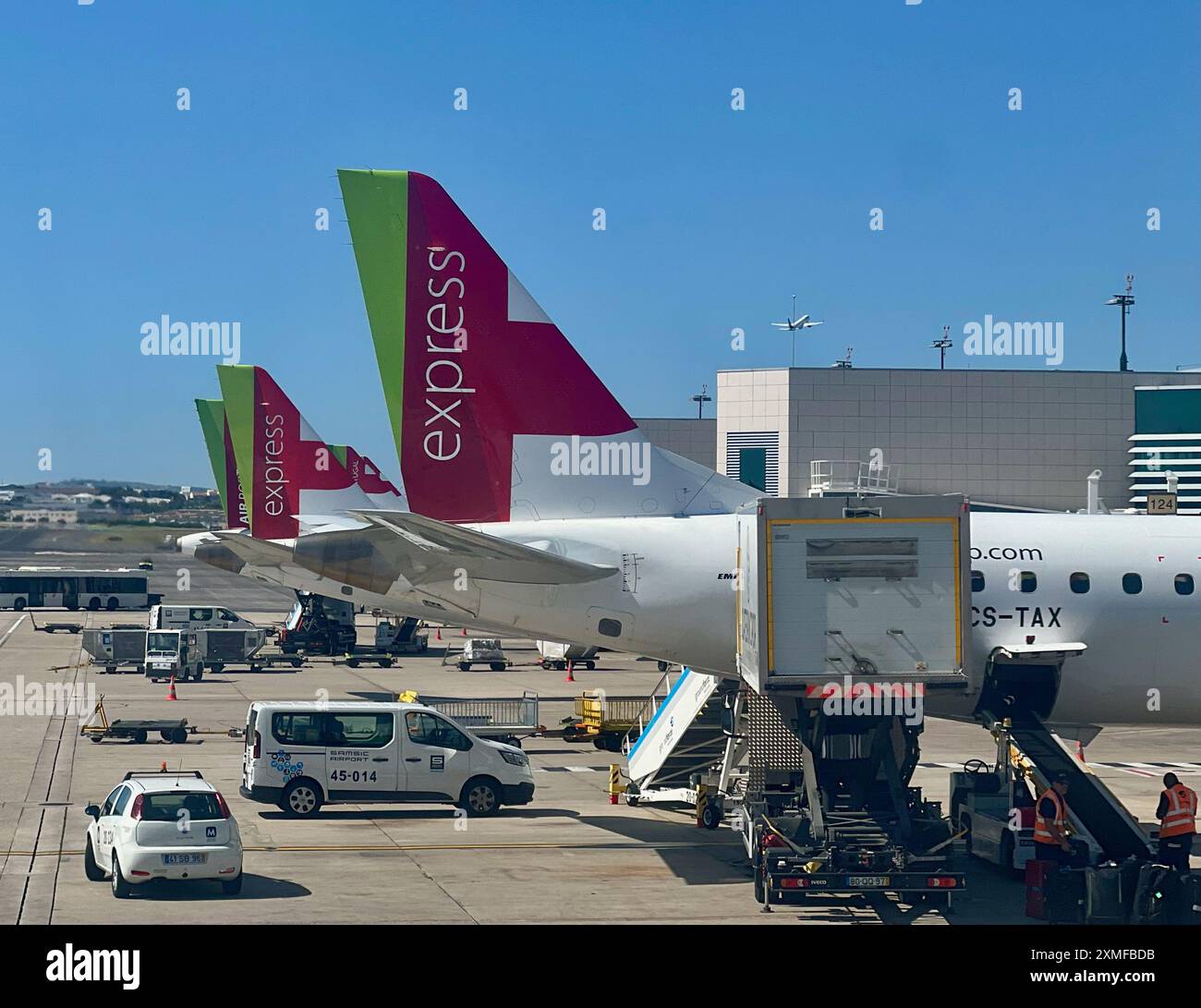 I lavoratori caricano gli aerei TAP Express all'aeroporto Humberto Delgado di Lisbona, Portogallo. Foto Stock