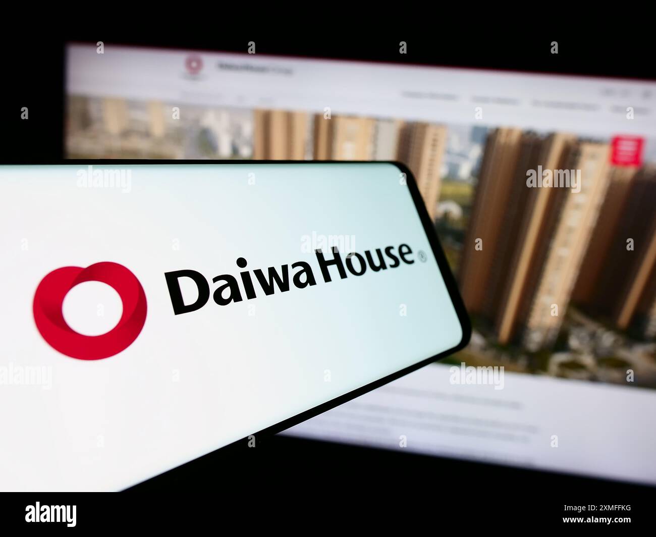 Telefono cellulare con logo della società di costruzioni Daiwa House Industry Co. Ltd. Di fronte al sito Web aziendale. Mettere a fuoco la parte centrale sinistra del display del telefono. Foto Stock