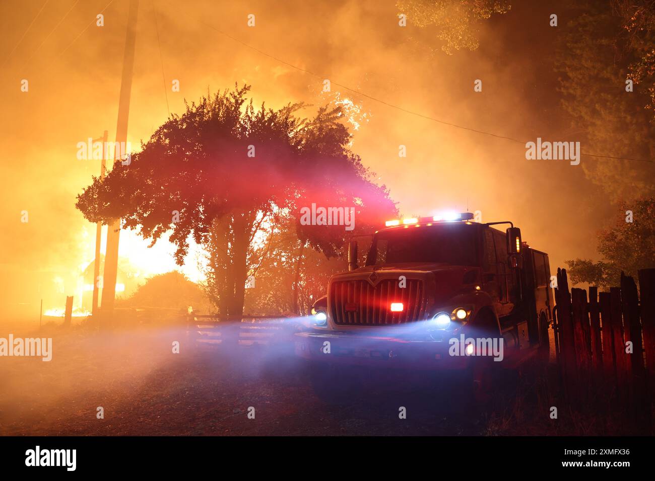 Le foto mostrano i vigili del fuoco che combattono contro le fiamme il 26 luglio 2024 in California, USA. Il più grande incendio attivo della California è esploso di dimensioni venerdì sera, crescendo rapidamente in mezzo al combustibile secco e minacciando migliaia di case mentre i vigili del fuoco si sono messi in difficoltà per affrontare il pericolo. L'intensità e la rapida diffusione del fuoco del Parco portarono i vigili del fuoco a fare confronti sgraditi con il mostruoso fuoco del campo, che bruciò fuori controllo nel vicino Paradise nel 2018, uccidendo 85 persone e bruciando 11.000 case. Più di 130 strutture sono state distrutte da questo incendio finora, e altre migliaia rimangono tre Foto Stock