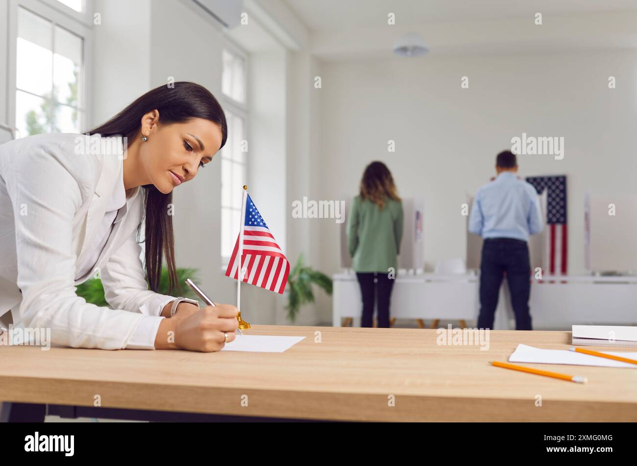 Una donna compila il modulo cartaceo sul tavolo al posto elettorale durante le elezioni americane Foto Stock