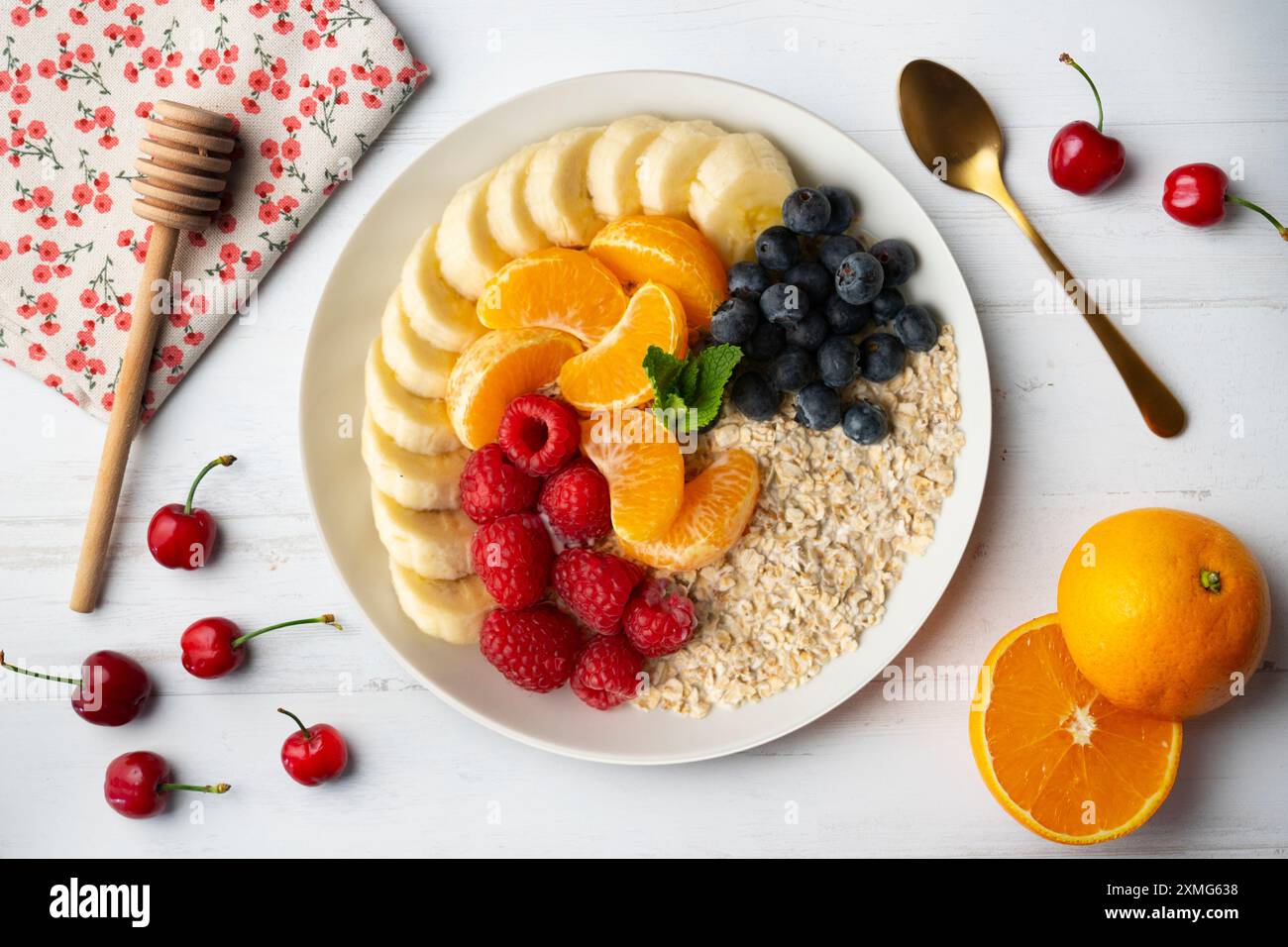 Deliziosa e sana ciotola di farina d'avena con mandarino, banana, mirtilli e lamponi. Foto Stock