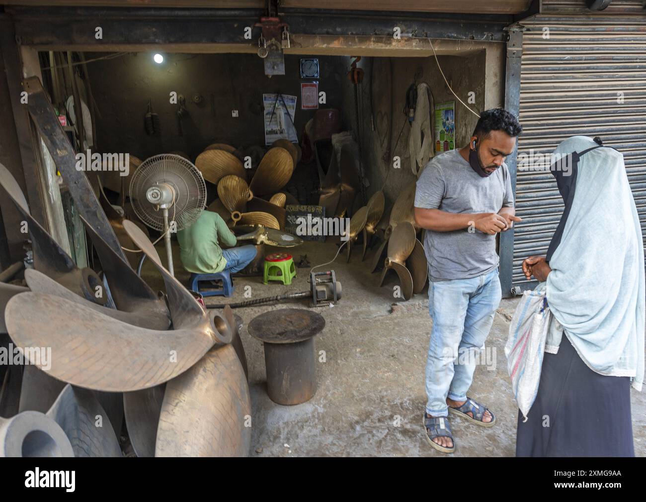Donna in burqa di fronte a un laboratorio di eliche, Divisione di Dhaka, Keraniganj, Bangladesh Foto Stock