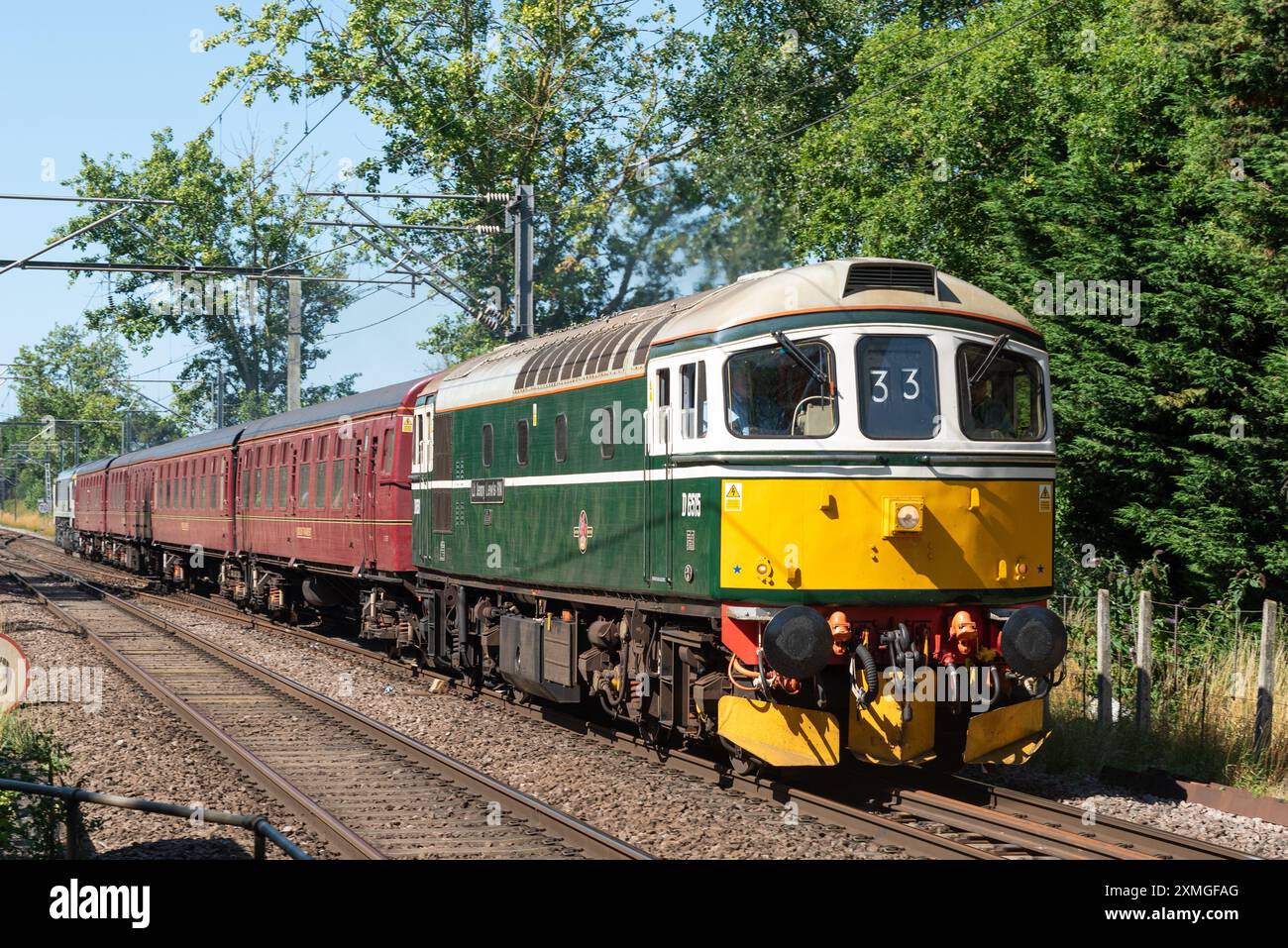 Ingatestone, Essex, Regno Unito. 28 luglio 2024. L'Organiser UK Railtours gestisce un treno passeggeri d'epoca diesel trainato dalla stazione di London Fenchurch Street alla città balneare di Clacton-on-Sea nell'Essex, utilizzando inizialmente una locomotiva della British Rail Class 33 numero D6515 degli anni '1960 fino ad Harwich. Una locomotiva di classe 66 trasporterà quindi il treno a Clacton e il viaggio di ritorno a Londra. 98 locomotive diesel-elettriche di classe 33 furono costruite tra il 1960 e il 1962 per la regione meridionale della British Railways, con l'ultima ritirata a metà degli anni 1990 Foto Stock