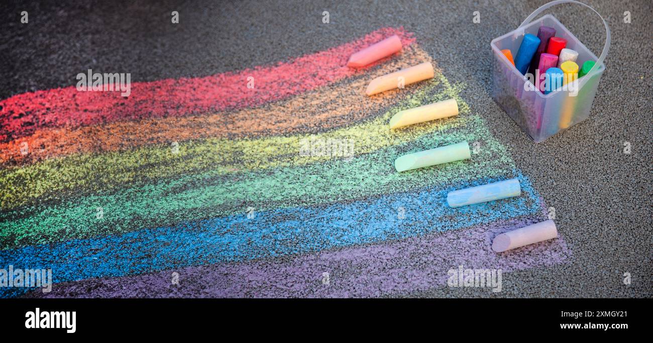 Disegno del gesso del marciapiede. Un arcobaleno dipinto sull'asfalto. Attività per bambini. I gessetti colorati aderiscono allo sfondo. Torna a scuola Foto Stock