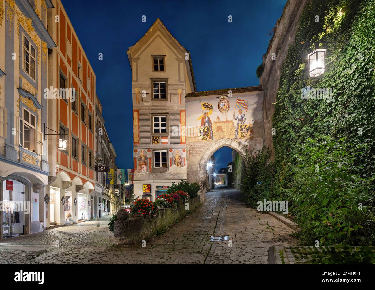 Steyr, Austria - luglio 28 2024: Vista della porta inferiore del castello di Lamberg e del Blumauerhaus al tramonto. L'affresco mostra l'imperatore Federico III e suo figlio Massimilia Foto Stock