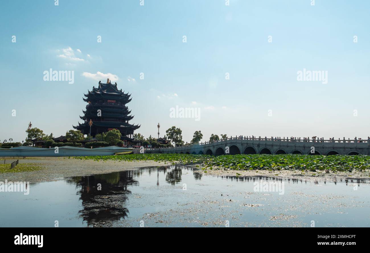 Suzhou, Cina - 24 settembre 2018: Padiglione tradizionale che si affaccia sul tranquillo corso d'acqua circondato da piante di loto sotto il cielo azzurro Foto Stock