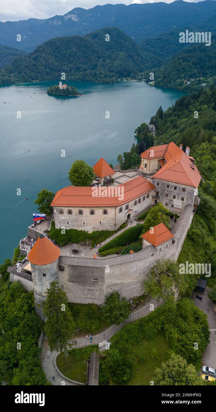 Vista panoramica aerea del bellissimo castello di Bled (Blejski Grad) con il lago di Bled (Blejsko Jezero), la chiesa dell'assunzione di Maria e il cielo coperto Foto Stock