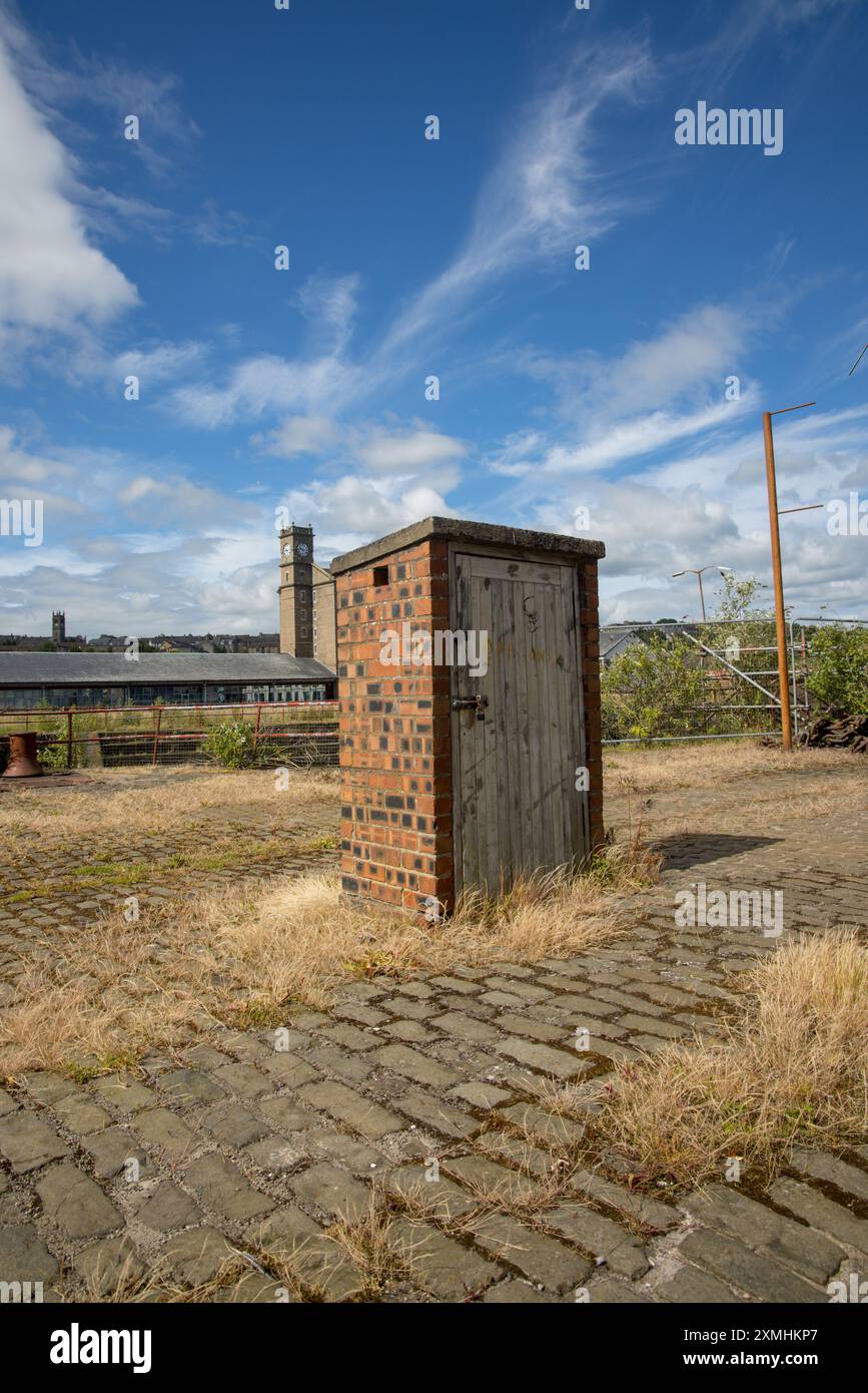 Piccolo capannone in mattoni con porta in legno, chiuso con serratura, nell'area di City Quay nel quartiere Waterfront di Dundee, Scozia, Regno Unito, Regno Unito Foto Stock