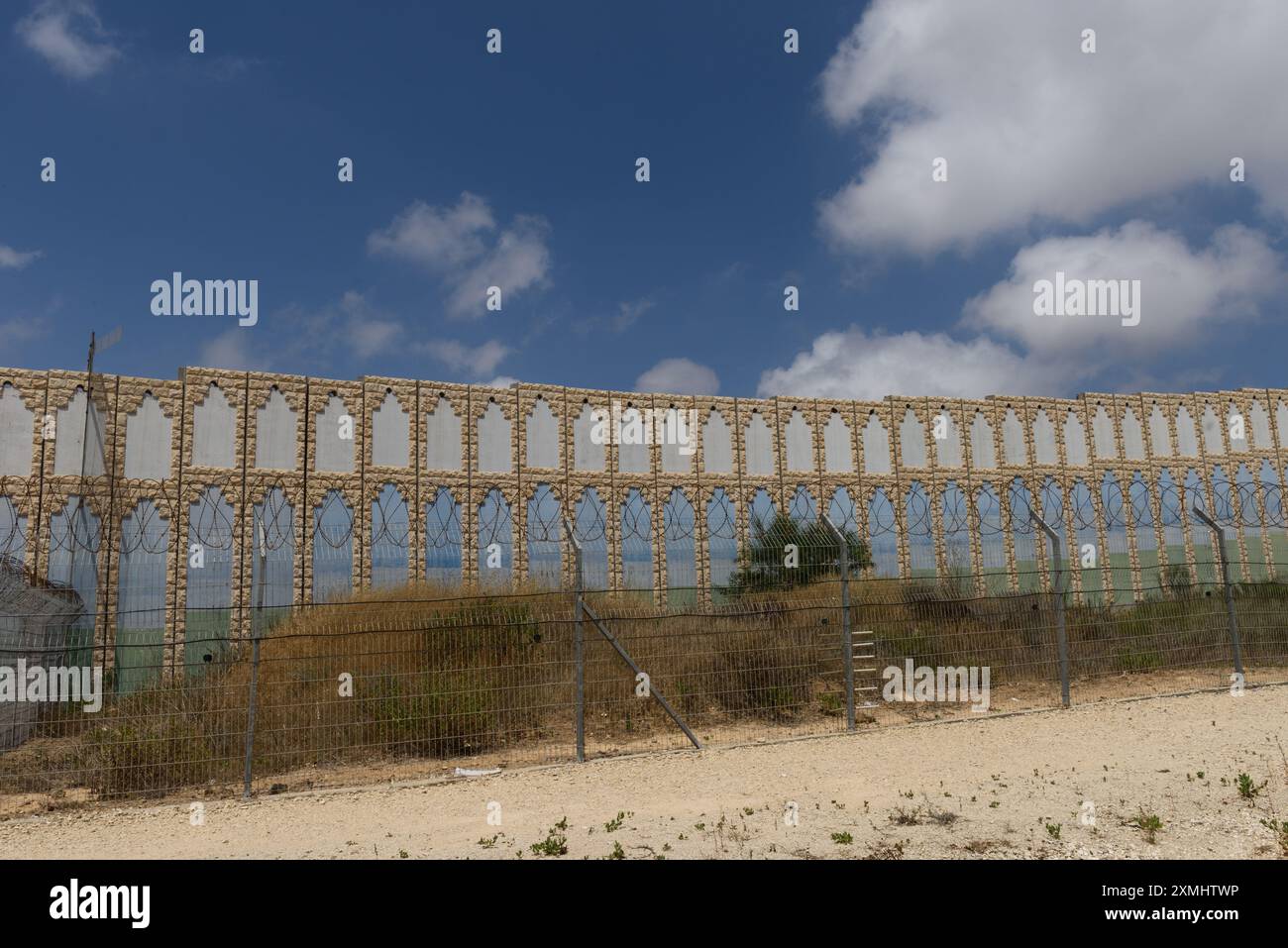 Alti blocchi di cemento formano una barriera di sicurezza sui bordi esterni del moshav Netiv HaAsara lungo il confine meridionale di Israele con la Striscia di Gaza. Foto Stock