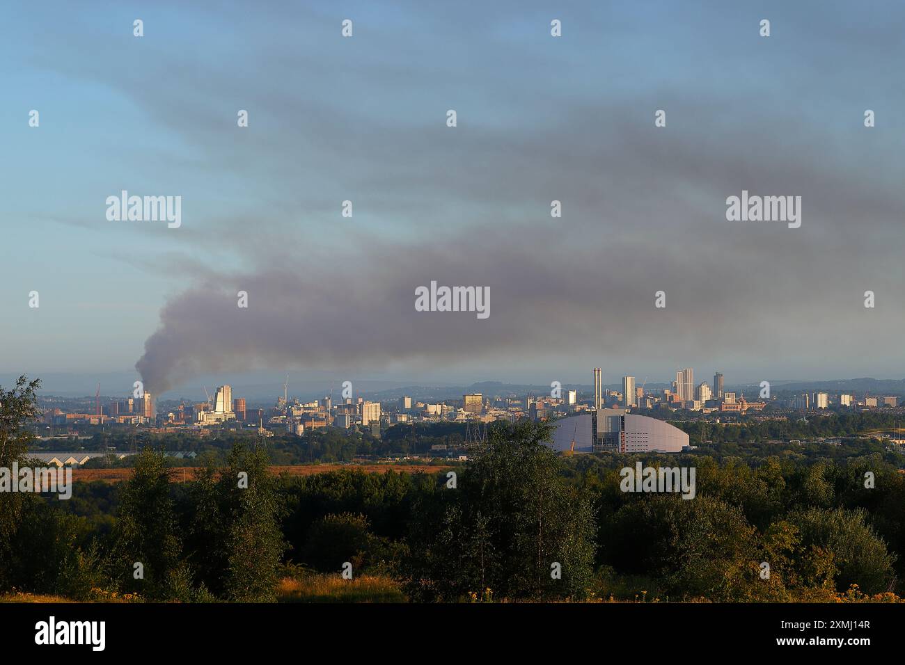 Lo skyline di Leeds City si trova a oltre 6 miglia di distanza a Rothwell. Il fumo può essere visto dall'edificio Canal Mills che ha preso fuoco il 28 luglio 2024 Foto Stock