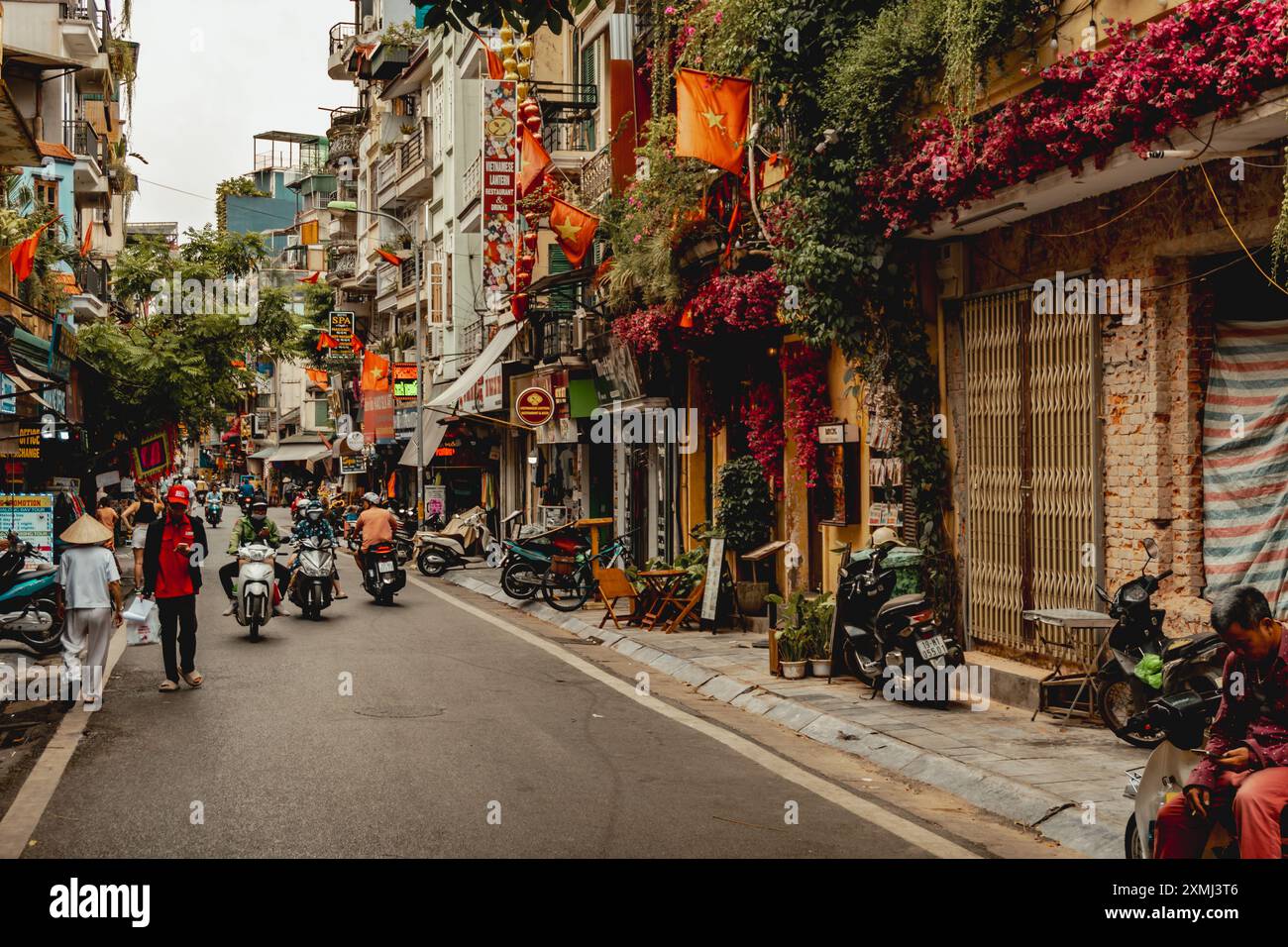 Scena di strada ad Hanoi con traffico scooter Foto Stock