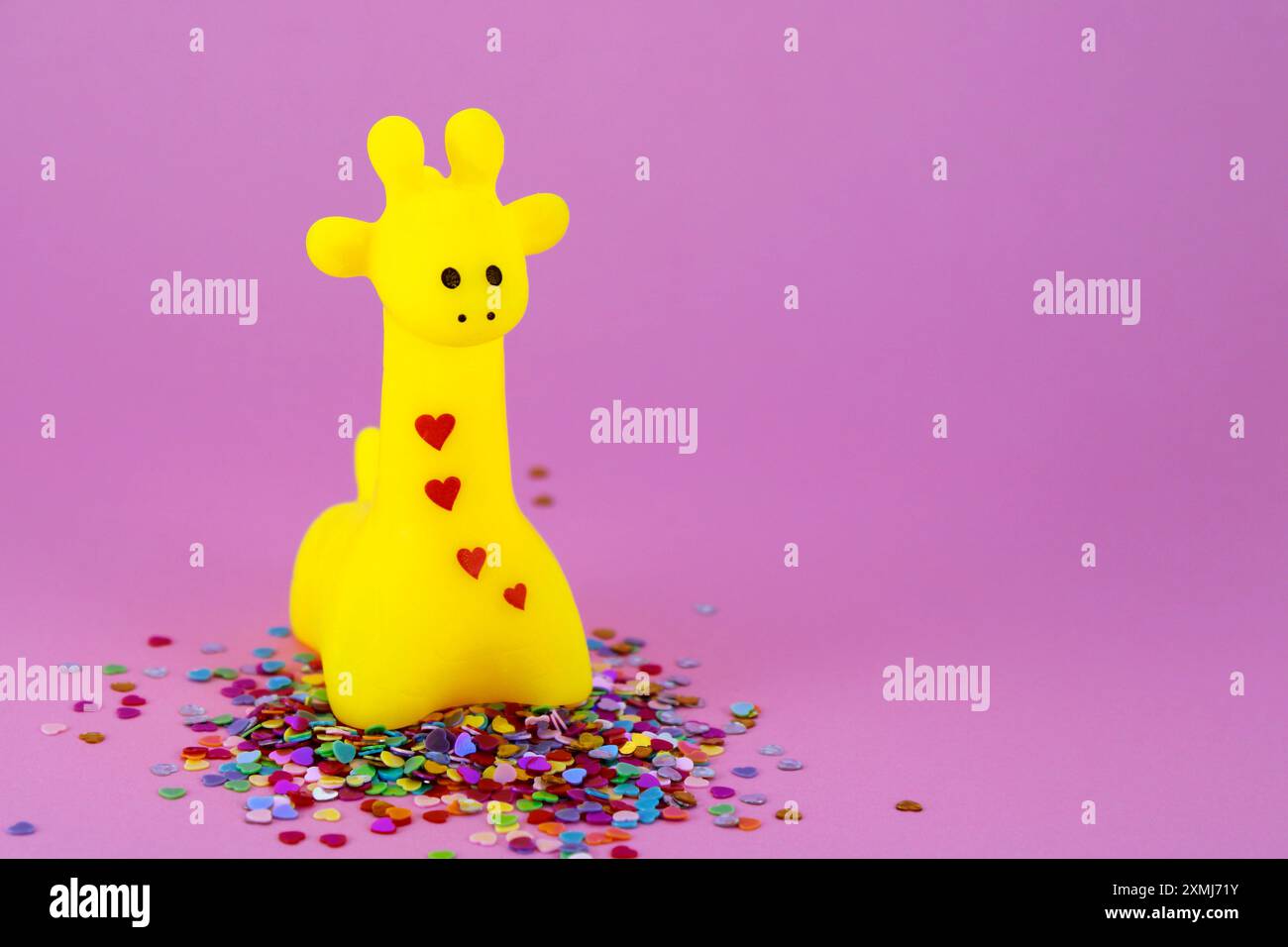 Graziosa giraffa gialla circondata da cuori Foto Stock