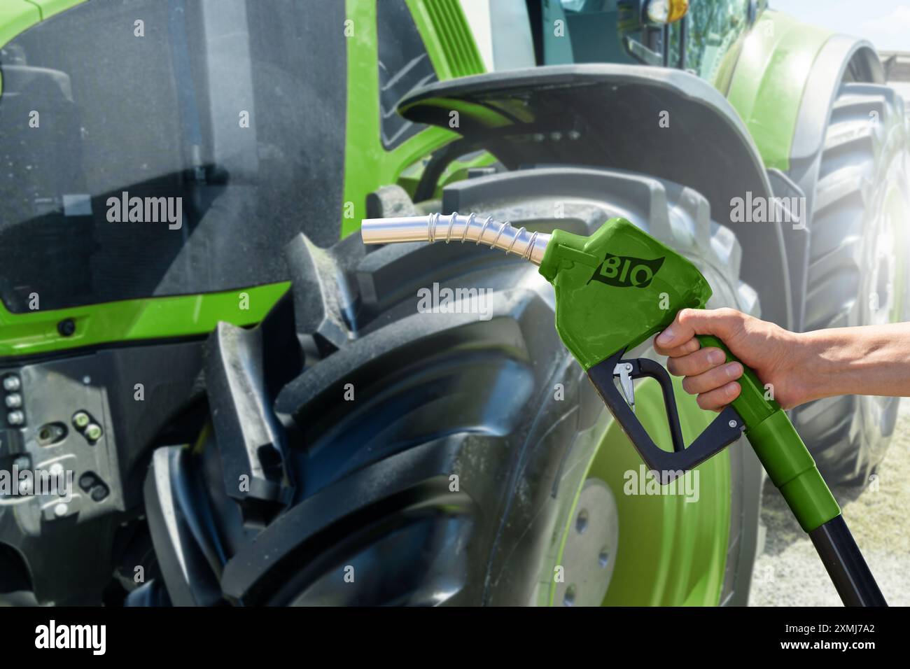 Utilizzare l'ugello di rifornimento del biocarburante sullo sfondo del trattore agricolo. Foto Stock