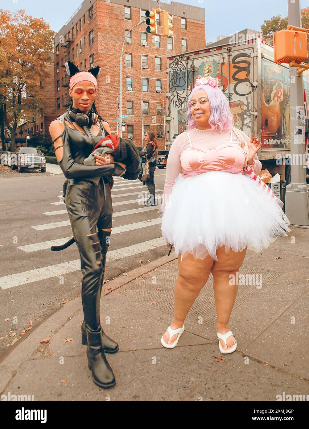 Brooklyn, New York, USA, 20 ottobre 2023. Donna e uomo in costumi di Halloween, lattice nero e vestito rosa Foto Stock