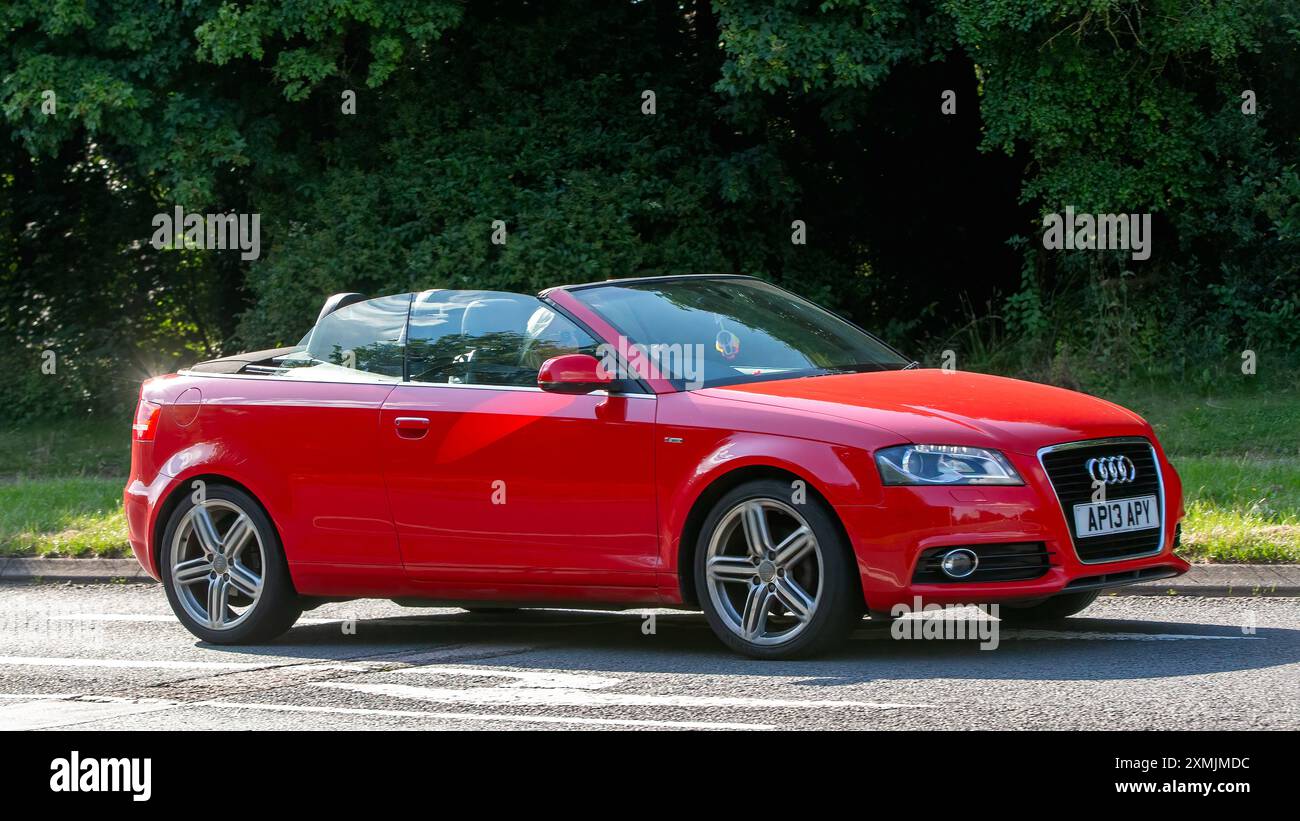 Milton Keynes, Regno Unito - 18 luglio 2024: 2013 Audi A3 rossa cabriolet che guida su una strada di campagna britannica Foto Stock