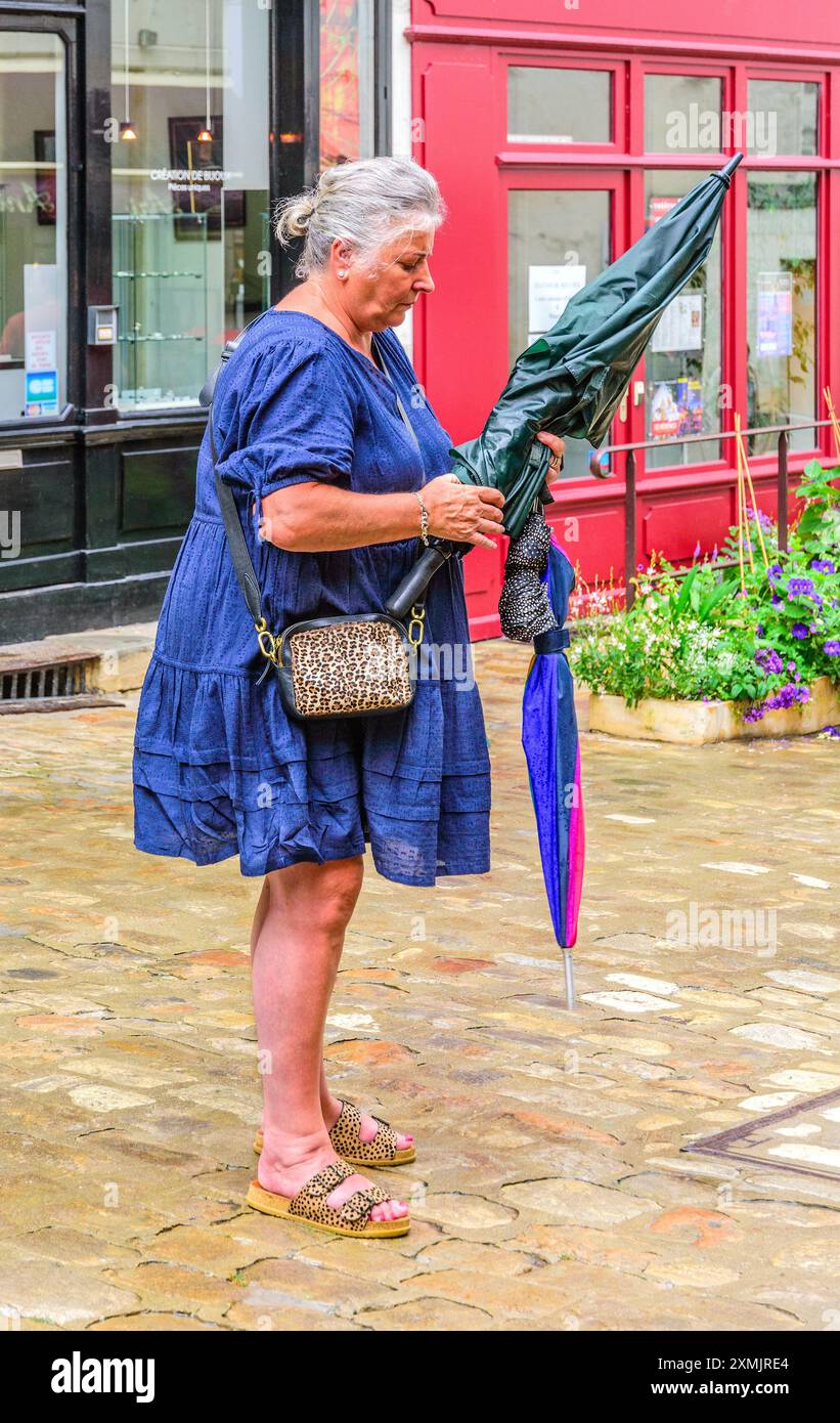 Ombrello donna di taglia superiore che inizia a piovere - Loches, Indre-et-Loire (37), Francia. Foto Stock