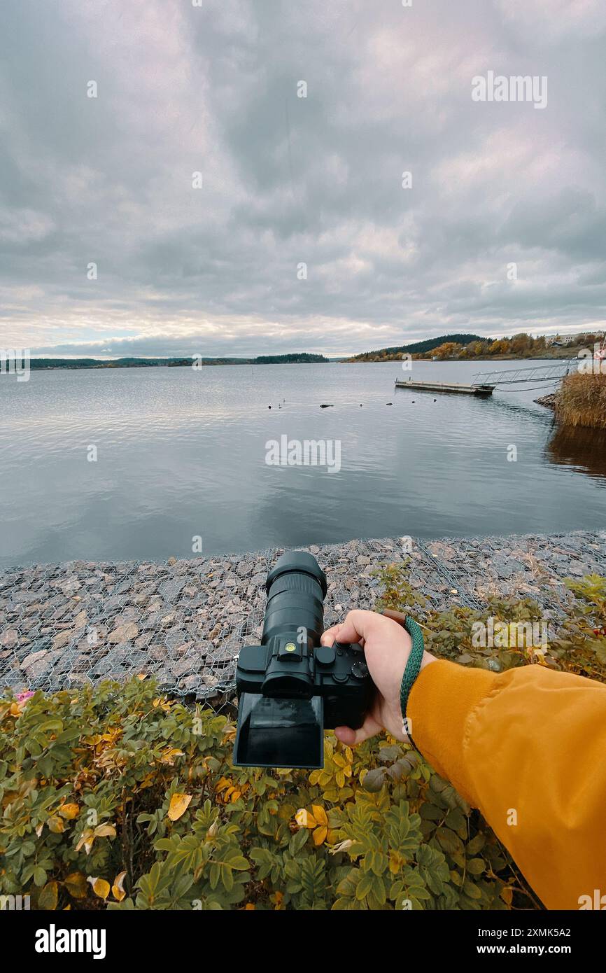 L'uomo fa una foto di un lago calmo Foto Stock