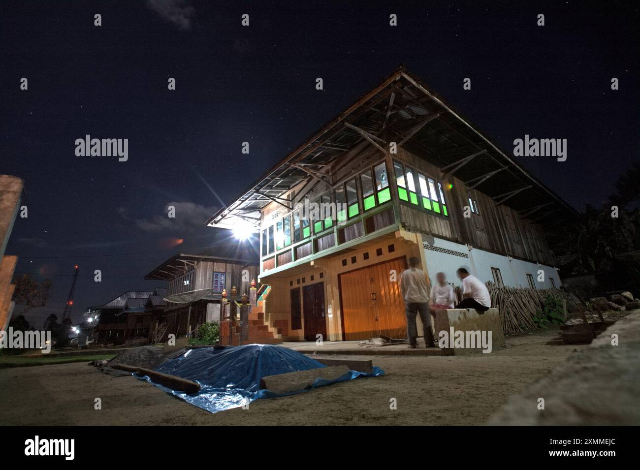 Giornalisti che hanno una conversazione con un proprietario di una casa in un quartiere residenziale costruito in stile architettonico tradizionale malese, a Liwa, provincia di Lampung, Indonesia. Foto Stock
