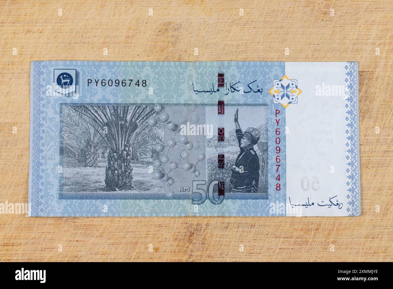 La banconota da 50 RM50 è stata emessa per commemorare il 50° anniversario dell'indipendenza malese, con date 1957-2007. Nota RM 50 su sfondo in legno Foto Stock