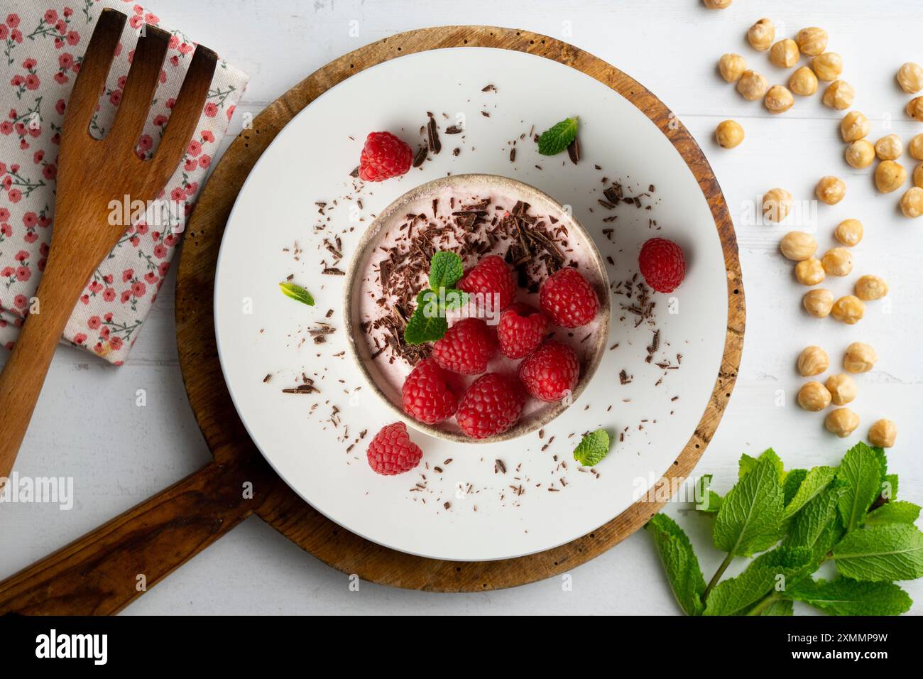 Deliziosa mousse di lamponi con frutti rossi da una prospettiva sopraelevata. Tavolo con decorazioni natalizie. Foto Stock