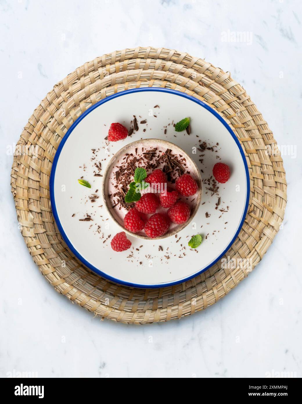 Deliziosa mousse di lamponi con frutti rossi da una prospettiva sopraelevata. Tavolo con decorazioni natalizie. Foto Stock