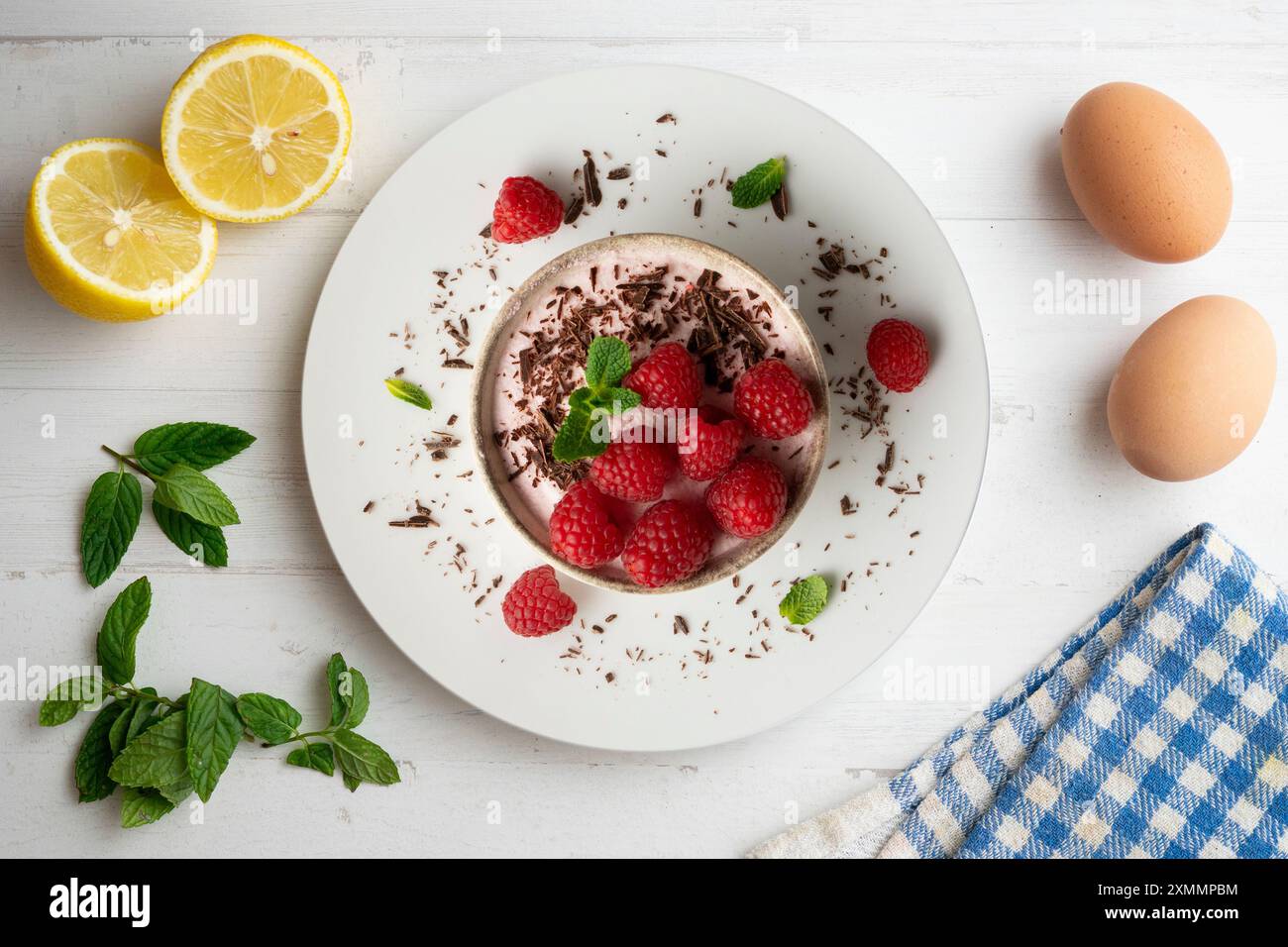 Deliziosa mousse di lamponi con frutti rossi da una prospettiva sopraelevata. Tavolo con decorazioni natalizie. Foto Stock