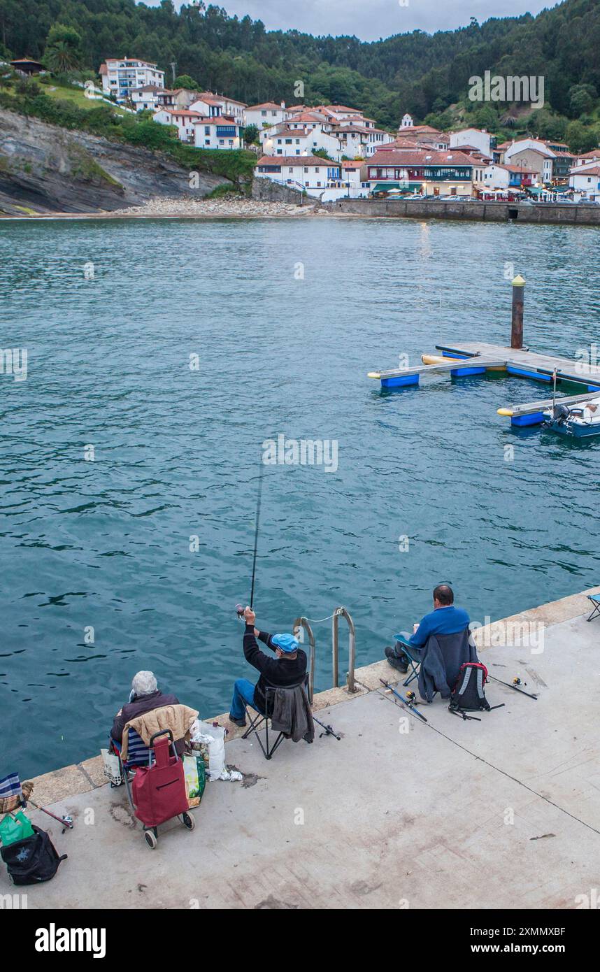Tazones, uno dei villaggi più belli della costa asturiana, Spagna. Pescatori di canne al molo Foto Stock