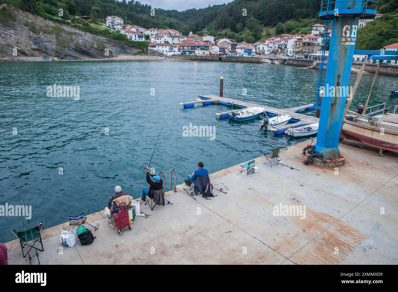 Tazones, uno dei villaggi più belli della costa asturiana, Spagna. Pescatori di canne al molo Foto Stock