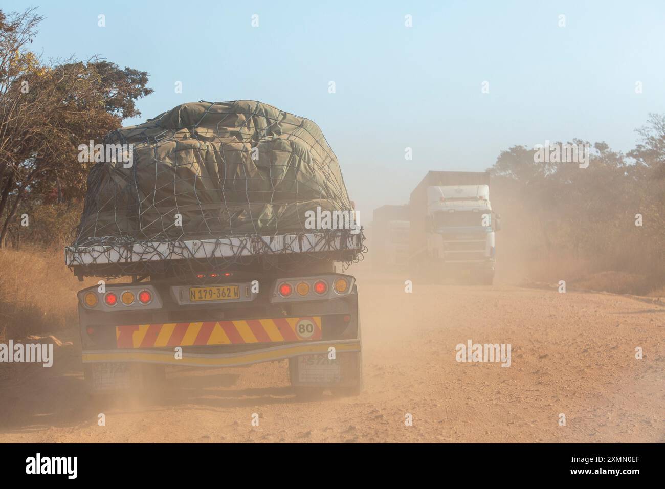 Camion merci che guida su un tratto della Great North Road in Zambia dove il catrame è scomparso Foto Stock